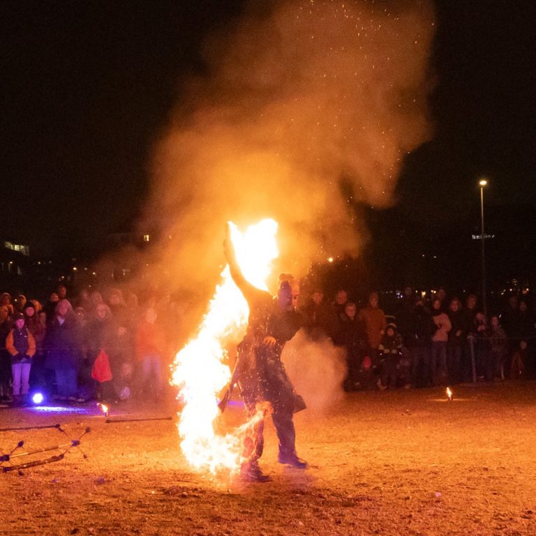 Feuerkünstler führt eine beeindruckende Darbietung vor einem erstaunten Publikum auf.